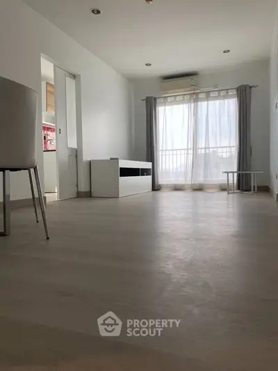 Spacious minimalist living room with large window and natural light