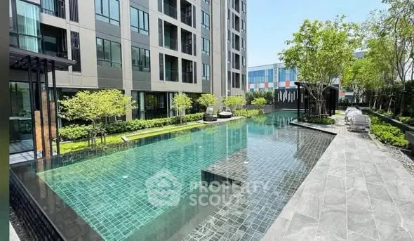 Luxurious apartment complex with stunning outdoor pool and lush greenery.