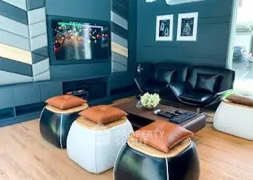 Stylish modern living room with unique seating and wall-mounted TV, perfect for entertainment.