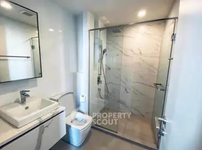 Modern bathroom with sleek fixtures and glass shower enclosure