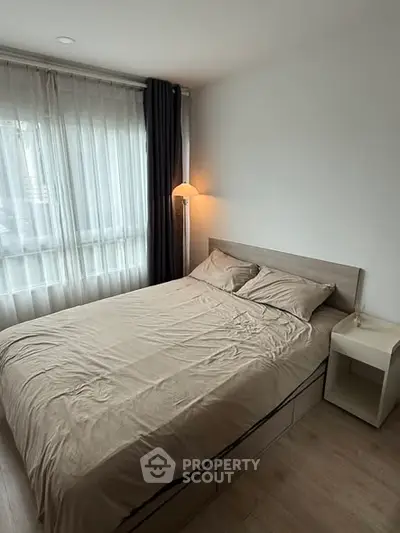 Cozy bedroom with modern decor and natural light in a stylish apartment.