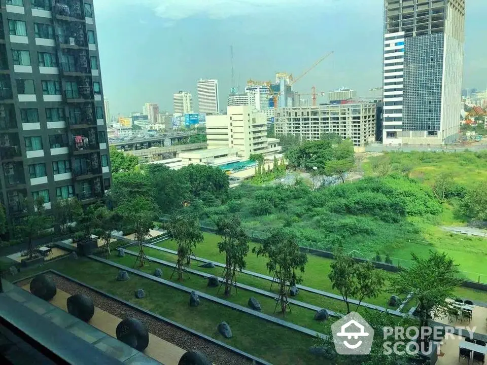 Stunning cityscape view from high-rise building with lush green garden below.