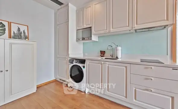Modern kitchen with white cabinetry and built-in washing machine