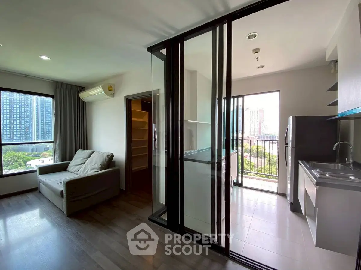 Modern apartment with open layout, large windows, and city view balcony.