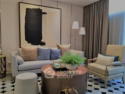 Elegant living room with modern decor, featuring a stylish sofa, armchair, and abstract art piece.