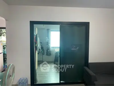 Modern living room with sliding glass door and cozy sofa, perfect for urban living.