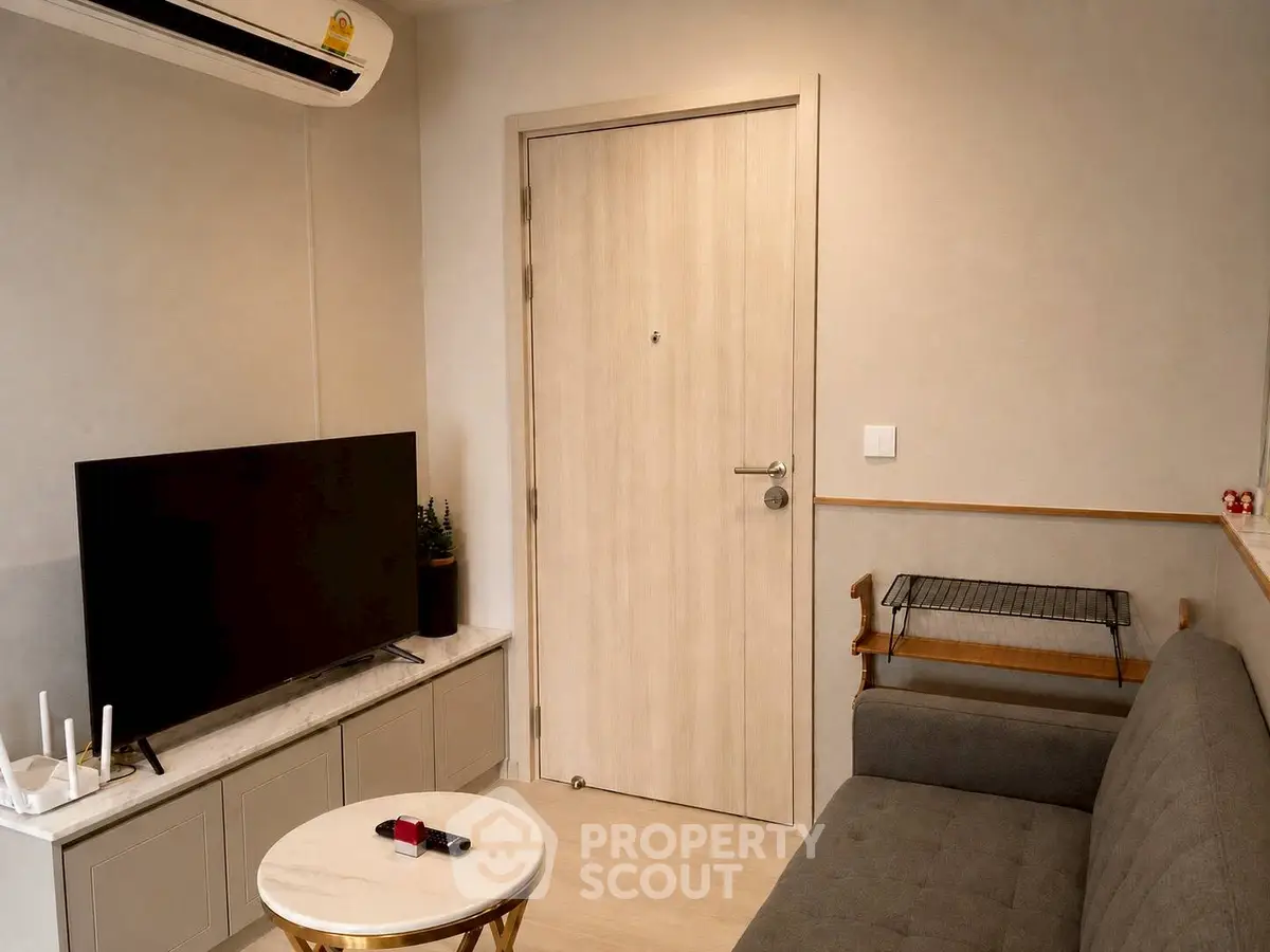 Cozy living room with modern decor, featuring a sleek TV setup and comfortable seating.