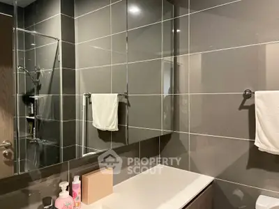 Modern bathroom with sleek tiles and mirrored cabinets