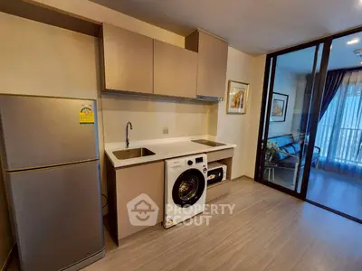 Modern kitchen with washing machine and fridge in open layout apartment