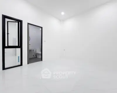 Minimalist white bathroom with modern fixtures and sleek design.