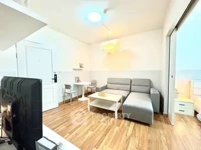 Modern living room with sleek furniture and wooden flooring in a cozy apartment.