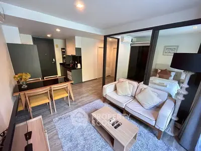 Modern open-plan living room with cozy seating and dining area, featuring stylish decor and ample natural light.