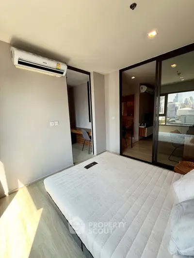Modern bedroom with city view, featuring sleek design and ample natural light.