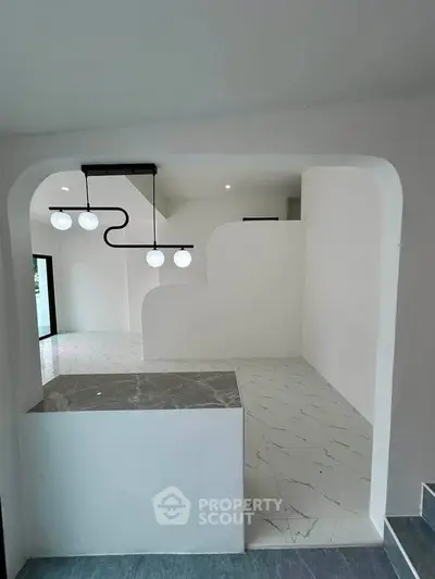 Modern minimalist interior with unique lighting and sleek marble flooring, perfect for contemporary living.