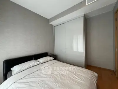 Modern bedroom with sleek design and ample natural light, featuring a large wardrobe and cozy bed.