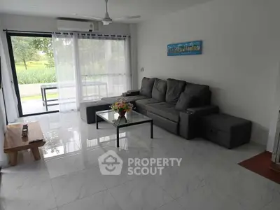 Spacious living room with modern furniture and garden view, perfect for relaxation and entertaining.