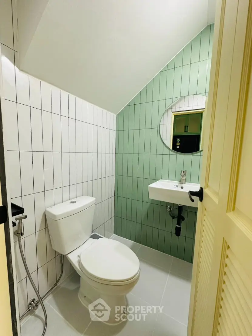 Modern bathroom with stylish green accent wall and compact design