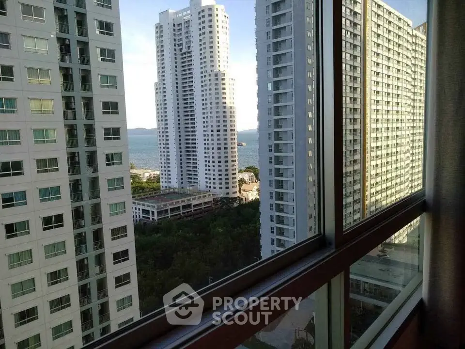 Stunning high-rise apartment view with ocean backdrop and modern architecture.