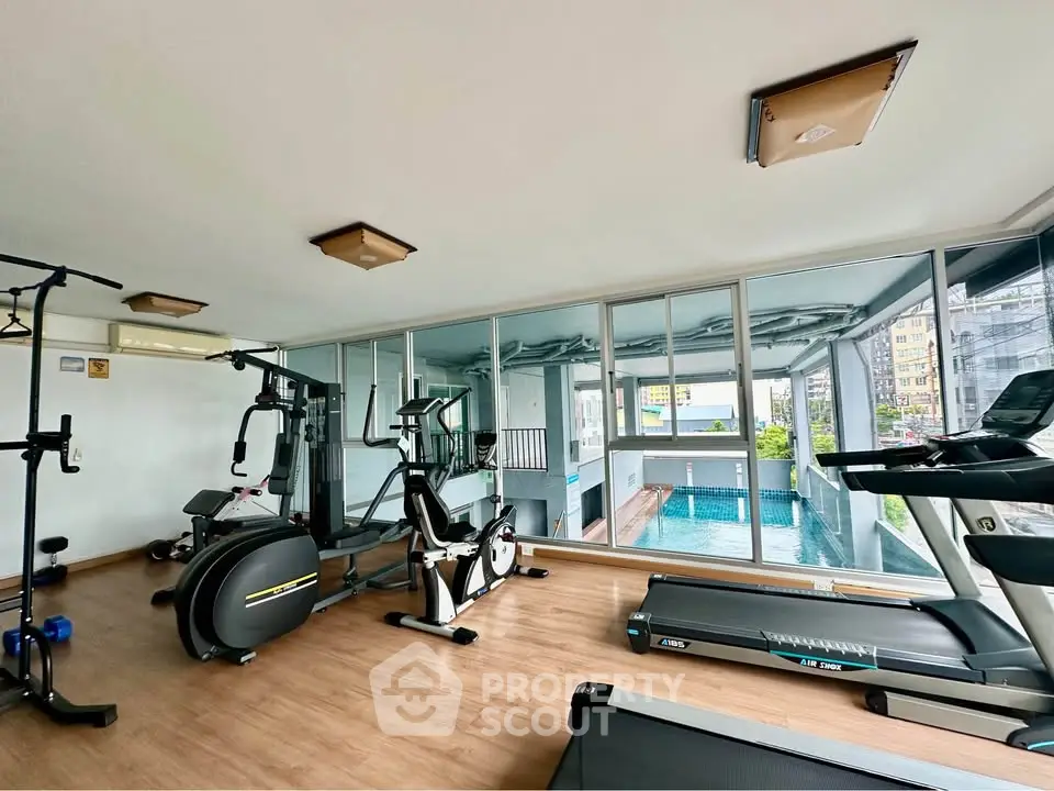 Modern gym with pool view in luxury condominium complex