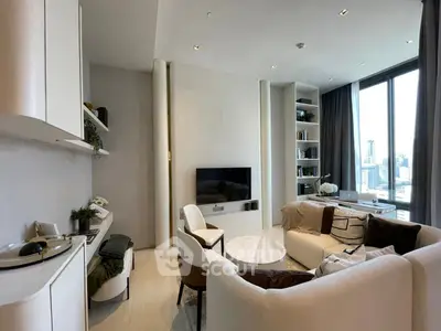 Modern living room with elegant decor and city view, featuring cozy seating and built-in shelves.