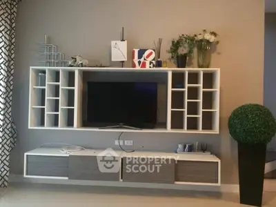 Modern living room with stylish wall-mounted TV unit and decorative shelving