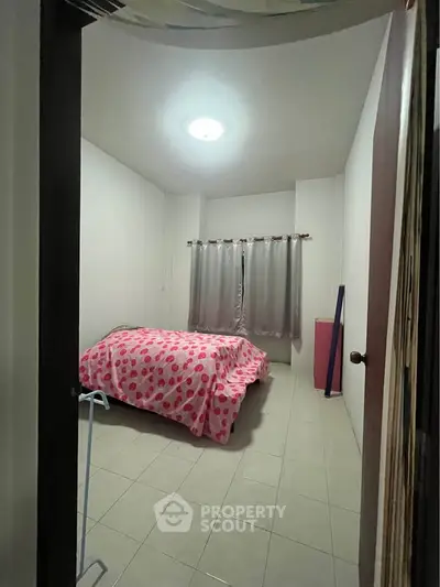 Cozy bedroom with tiled floor and pink polka dot bedding, perfect for a restful retreat.