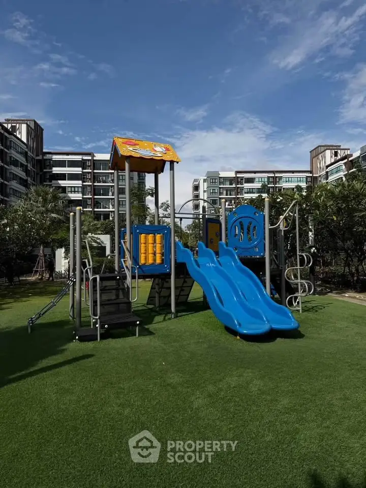 Modern residential complex with children's playground and lush greenery