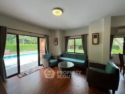Spacious living room with pool view and elegant wicker furniture