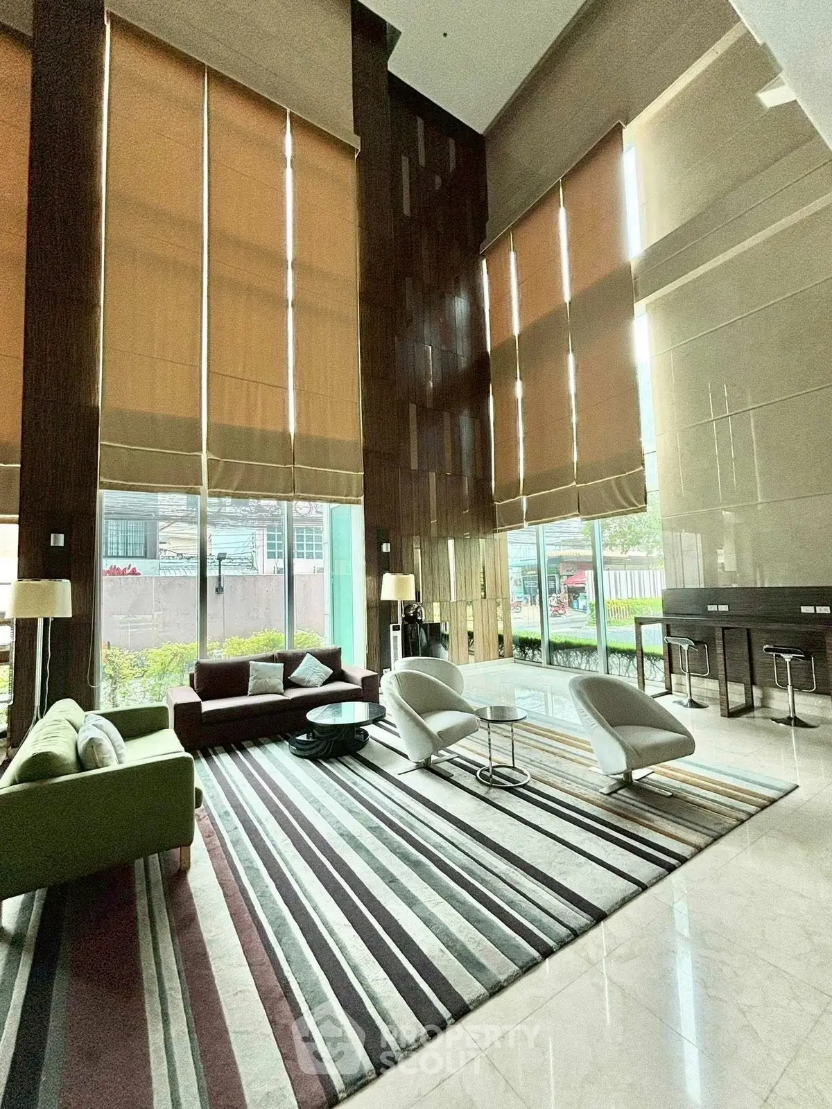 Luxurious high-ceiling living room with modern furniture and large windows.