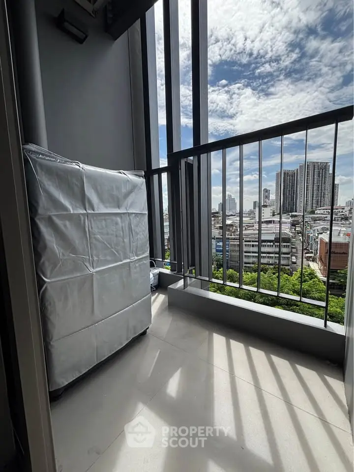Modern balcony with city skyline view and covered appliance, perfect for urban living.