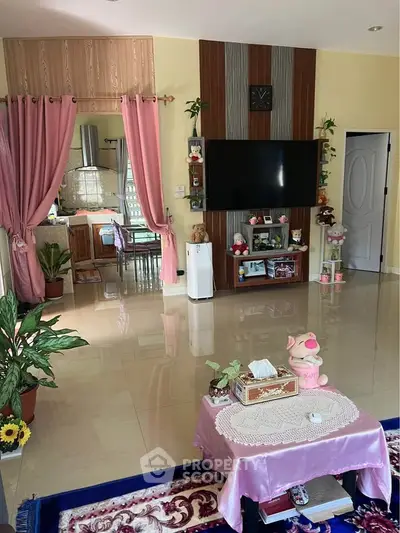Charming living room with modern decor and open layout leading to a cozy kitchen, perfect for family gatherings.