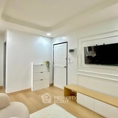 Modern minimalist living room with sleek white furniture and wooden flooring