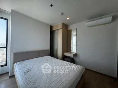 Modern bedroom with large window and minimalist design in high-rise apartment.
