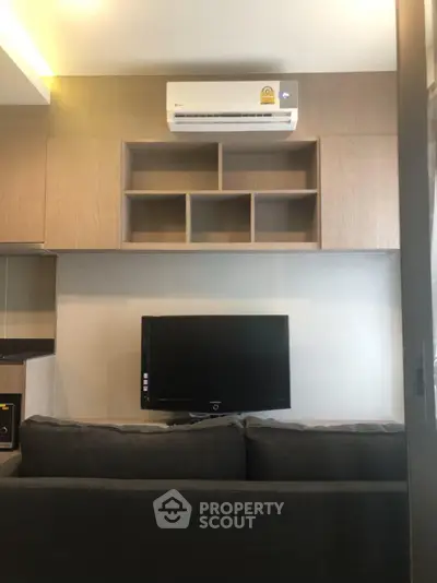 Modern living room with wall-mounted TV and air conditioning unit