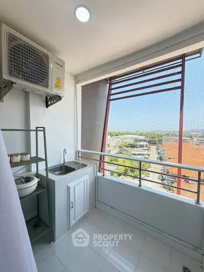 Charming balcony with sink and air conditioning unit, offering a scenic city view.