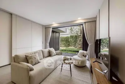 Luxurious living room with modern decor and garden view, featuring plush sofa and sleek entertainment unit.