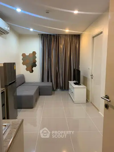 Modern living room with sleek design, featuring a gray sofa, wall-mounted TV, and stylish decor.
