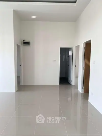 Spacious modern interior with sleek tile flooring and minimalist design, perfect for customization.