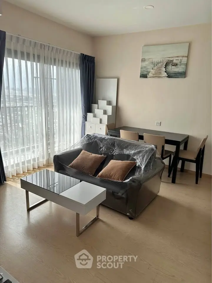 Modern living room with natural light, stylish furniture, and a scenic balcony view.