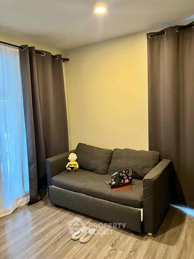 Cozy living room with dark curtains and a comfortable sofa, perfect for relaxation.