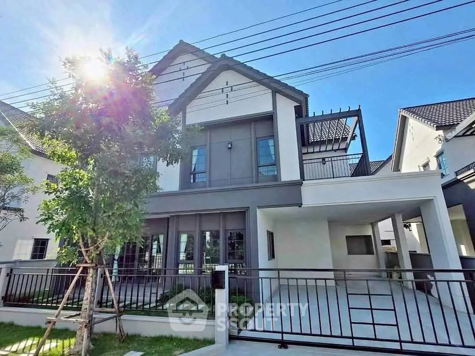 Modern two-story house with sleek design and spacious driveway under clear blue sky.