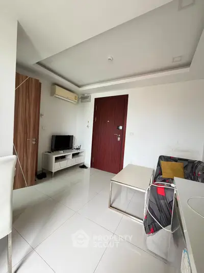Modern living room with sleek design, featuring a TV, air conditioning, and stylish furniture.