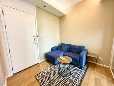 Cozy living room with blue sofa and stylish rug in modern apartment