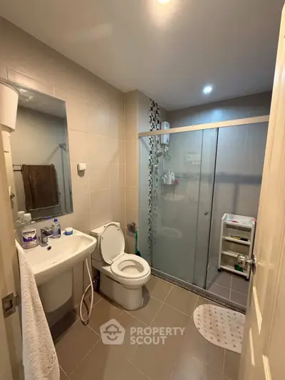 Modern bathroom with glass shower and sleek fixtures in a contemporary home.