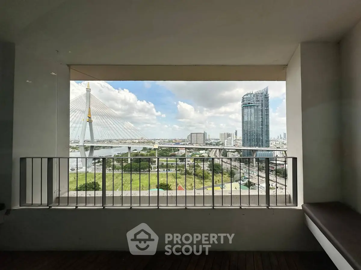 Stunning cityscape view from a modern apartment balcony overlooking a bridge and skyscrapers.