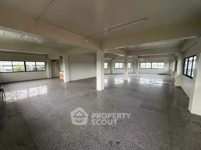 Spacious open-plan interior with large windows and polished flooring, ideal for versatile use.