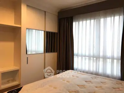 Cozy bedroom with large window and built-in wardrobe, perfect for relaxation and comfort.
