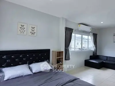 Modern bedroom with stylish decor and natural light, featuring a cozy bed and elegant wall art.