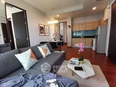Modern living room with open kitchen, stylish decor, and cozy seating area in a contemporary apartment.