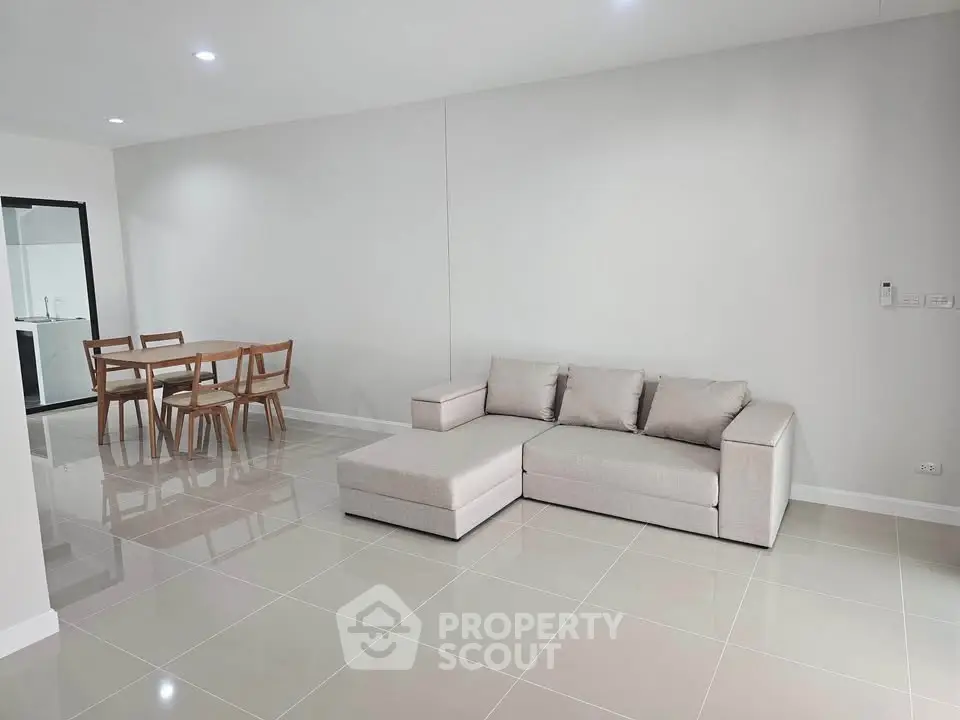 Spacious modern living room with sleek tile flooring and elegant dining area